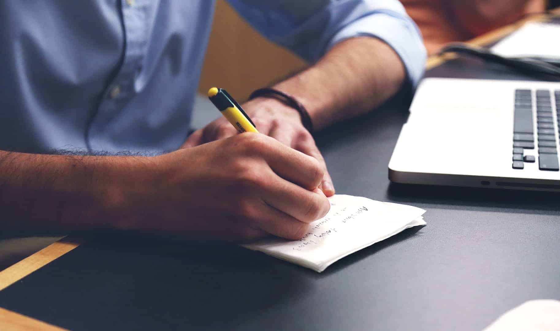 Beginner vlogger writing video plan in notebook