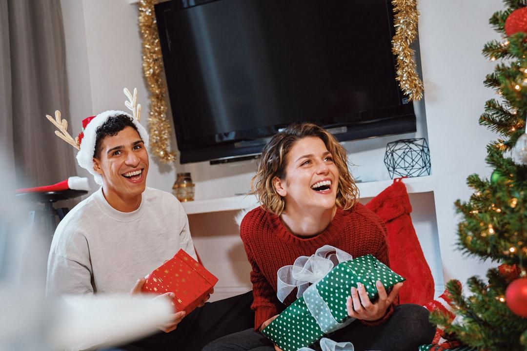A candid photo of a family laughing together while wearing ugly Christmas sweaters