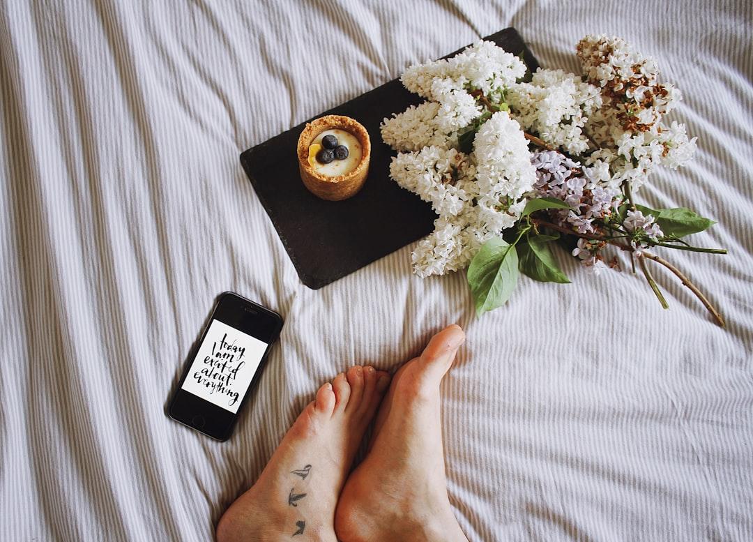 Ein flaches Bild mit einem Smartphone, das einen Instagram-Post, eine Kaffeetasse und eine kleine Blume zeigt.