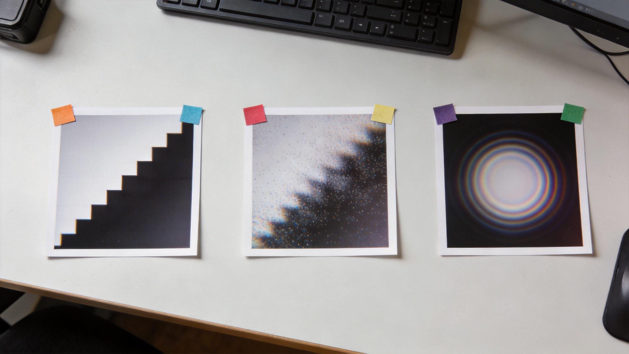 Three pinned prints on a desk showing stepped, pixelated, and blurred circular patterns